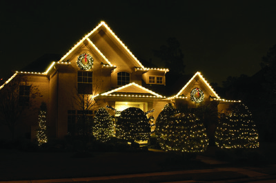 Two-story home with classic white Christmas lights and tree wrapping lights
